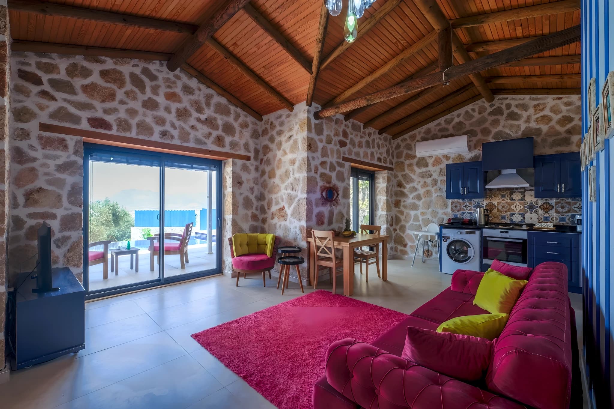 Open-plan living and kitchen space with colorful furnishings and sea views.