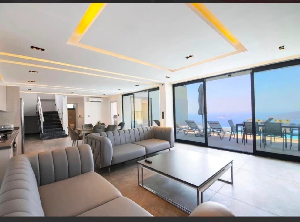 Spacious living room with wraparound sea views and modern furnishings.