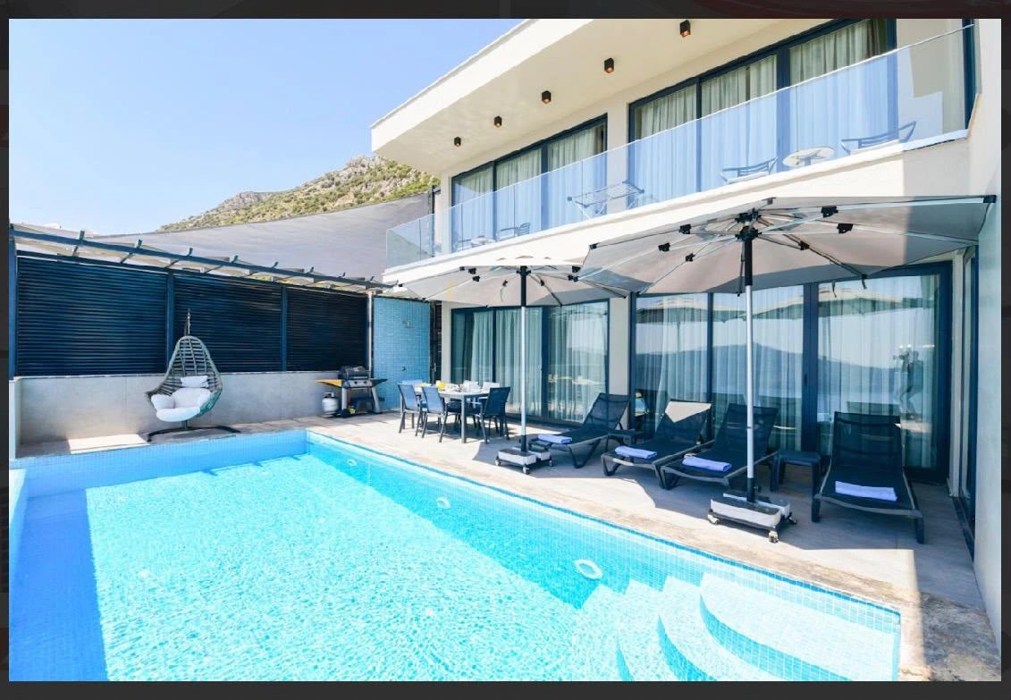 Private pool with lounge seating and covered terrace overlooking hillside landscape.