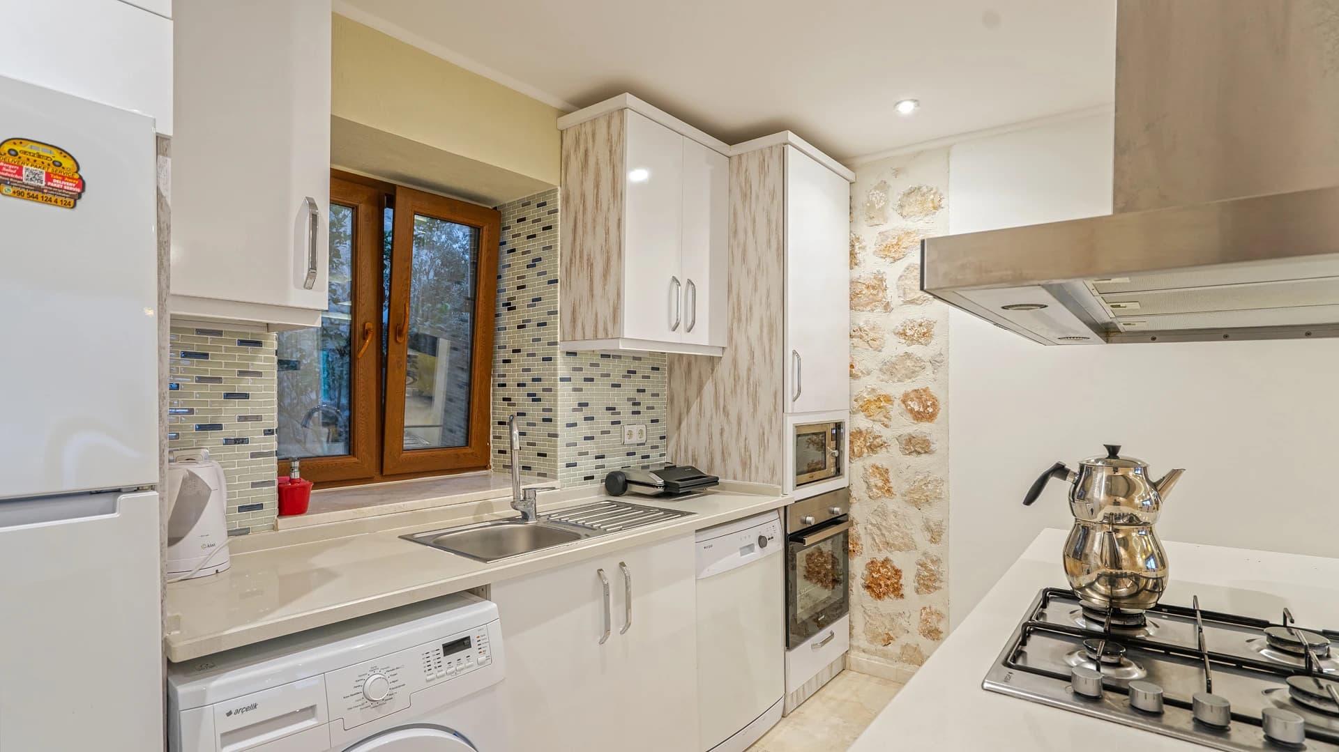 Modern kitchen with gas stove, dishwasher, and tiled backsplash.