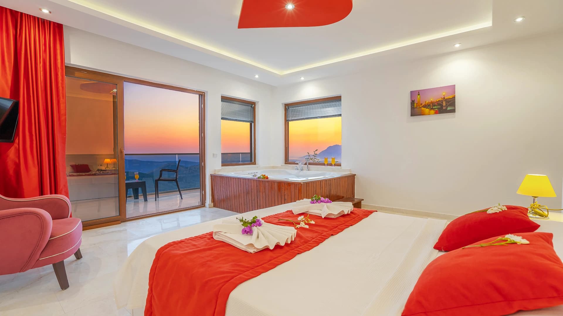 Luxury bedroom with two beds overlooking the sea at sunset.