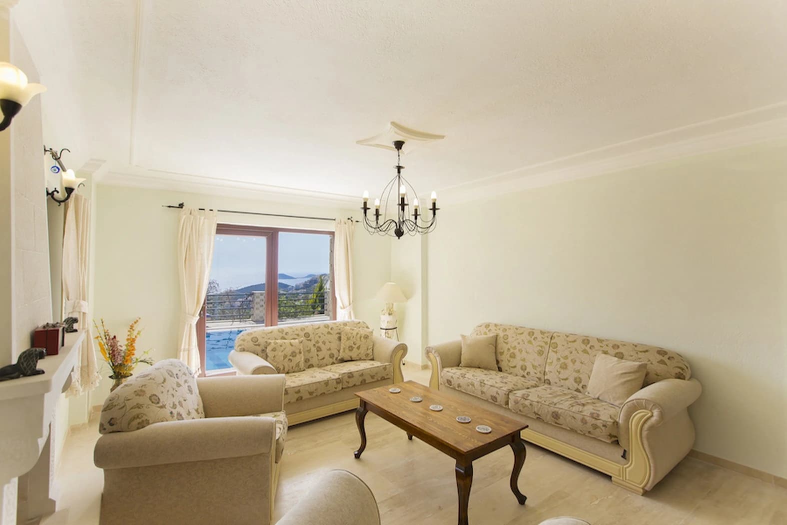 Elegant living room with comfortable seating and expansive mountain views through glass doors.