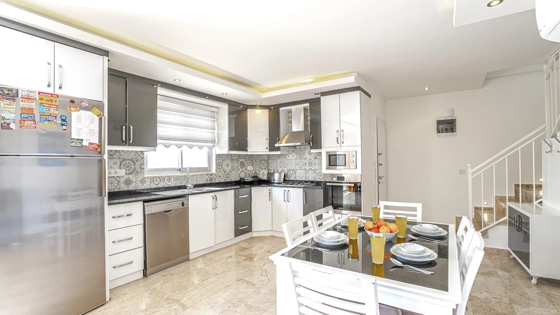 Abgeschiedene 2-Zimmer-Villa mit beheiztem Pool und Berg- & Meerblick in Kalkan – Spacious modern kitchen with island and integrated dining area, featuring quality appliances and stylish tile work.